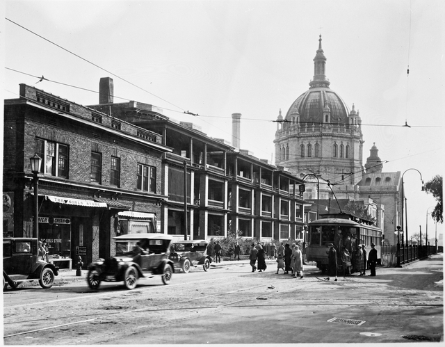 Passengers board a streetcar in St. Paul with the Cathedral of St. Paul in the background.
